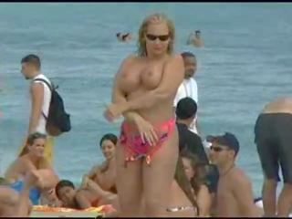 Toppløs blond moving pupper ved strand